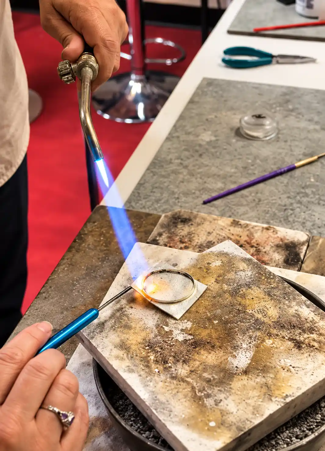 Silver jewelry being soldered during a hands-on workshop in Ubud